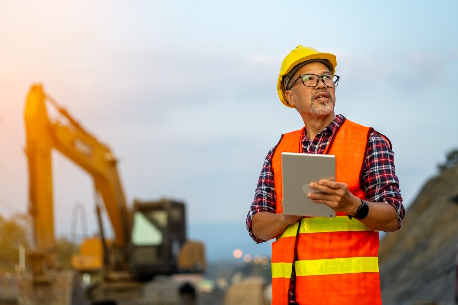 Male engineer uses tablet to plan work in road construction area