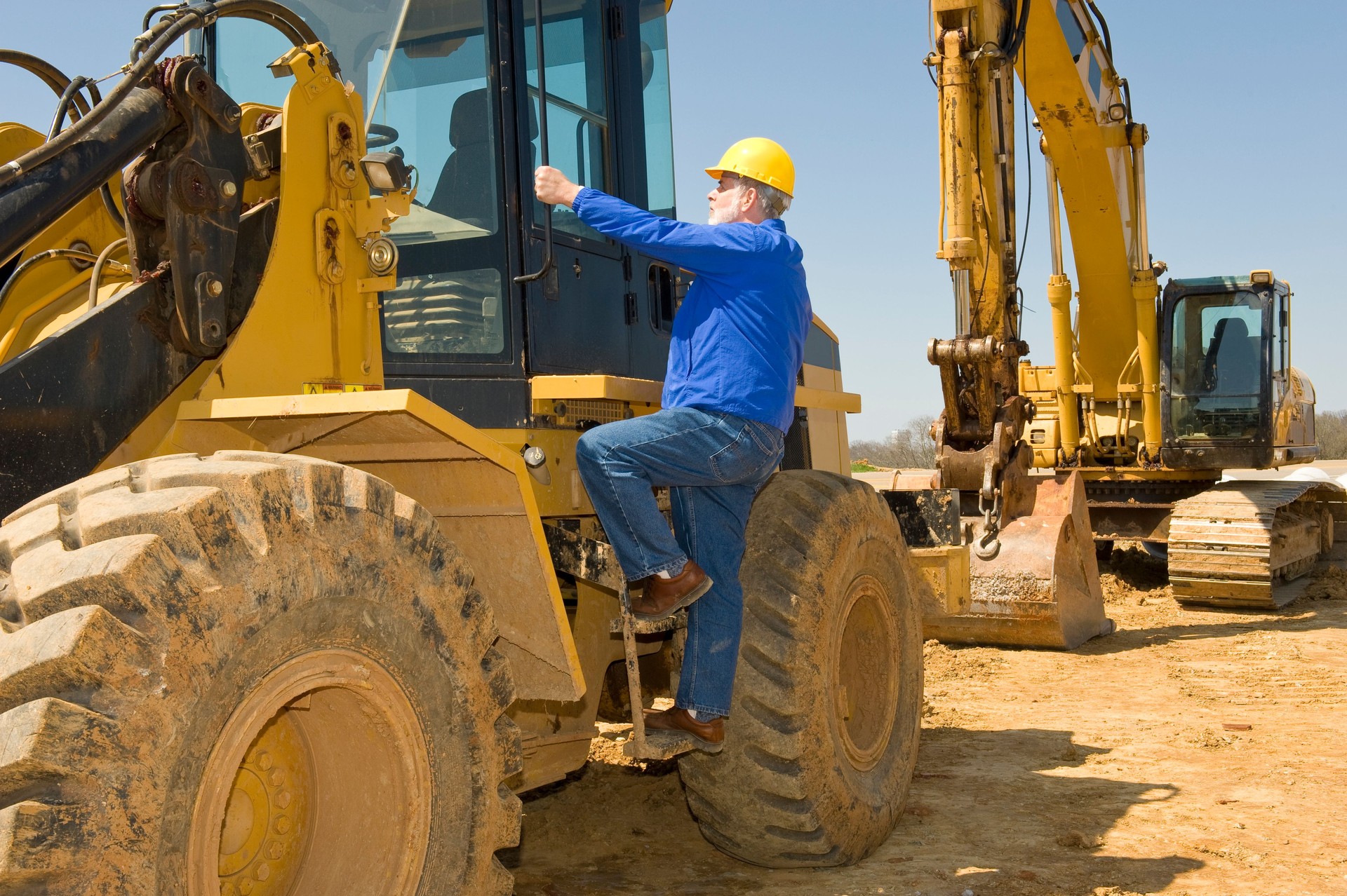 Heavy Equipment Operator Climbing Into Cab